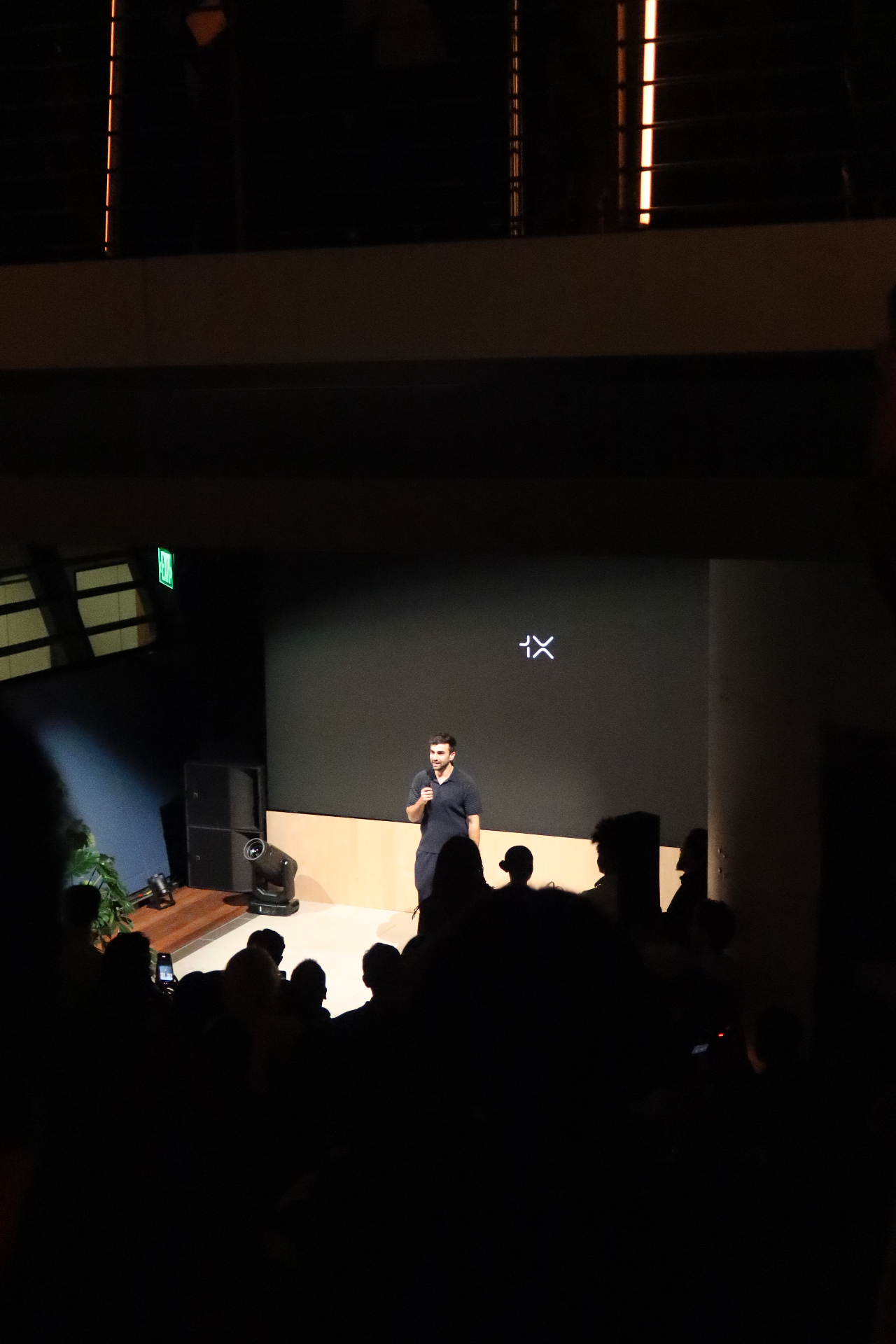 Keynote speaker on stage with branded backdrop